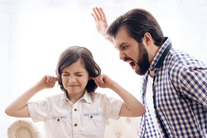Bearded angry father scolds crying son. Adult man yells at frustrated little boy. Rough parenting. figli urla grida urlare