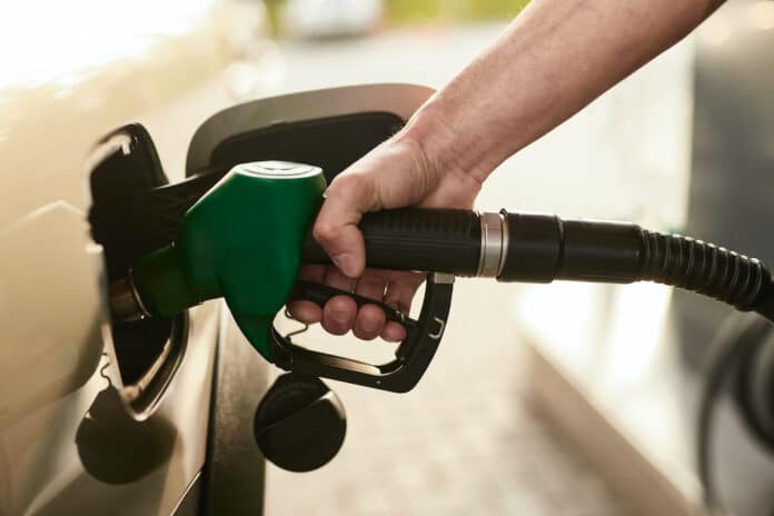 BENZINA RAMAZZINI Crop man refueling car at station BENZINA RAMAZZINI