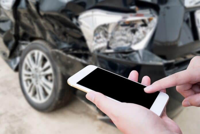 Female using mobile phone after car accident cid