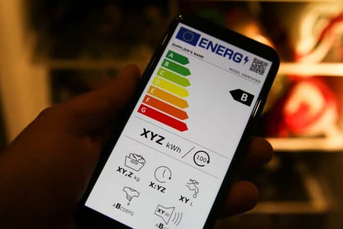 Viresen, Germany - May 8. 2021: Closeup of mobile phone screen with new european union energy label efficiency classes A - D, blurred fridge backgound smartphone