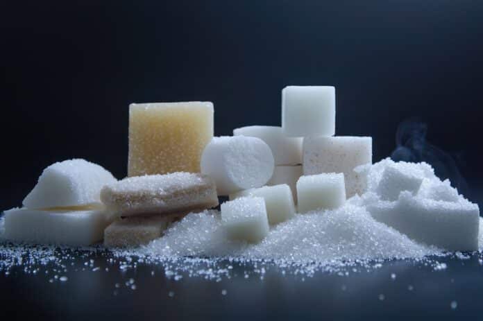 Pile of white and brown sugar cubes and granules dolcificanti