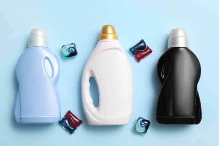 Bottles of detergent with capsules on blue background DETERSIVI