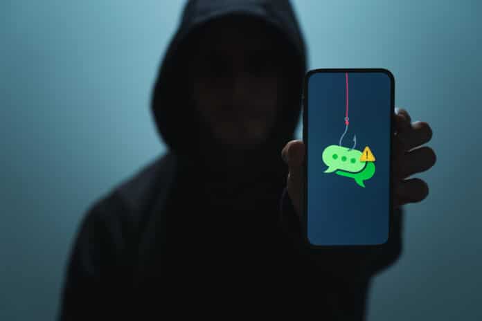 TRUFFA SMS Suspicious Man with Phone Representing SMS Phishing Scam (Smishing) TRUFFA SMS