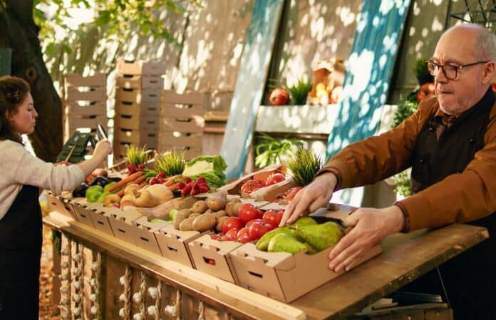 Team of local farmers putting price tags and arranging products CAMBIAMENTI CLIMATICI