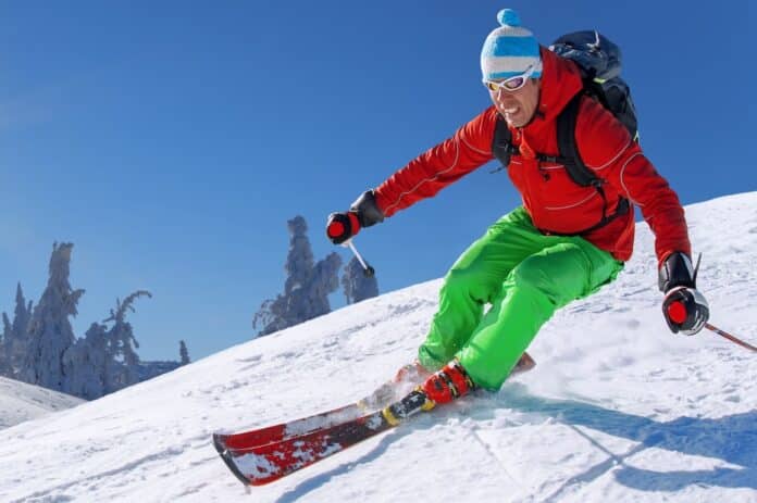 Skier skiing downhill in high mountains against blue sky sci