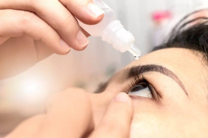 Closeup woman using eye drop. Woman applying eye drops healthcare concept.