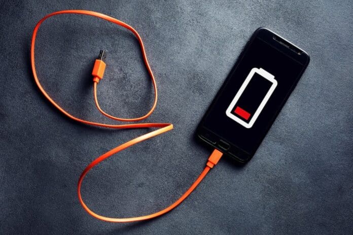Smartphone with low battery icon and a disconnected usb charging cable RICARICARE LA BATTERIA
