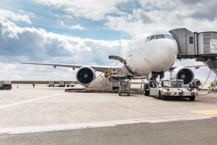 The white Unrecognizable plane at the airport takes passengers through a telescopic ladder voli aerei