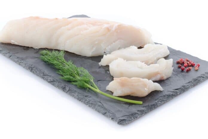 Fresh raw cod fillet on a slate plate MERLUZZO
