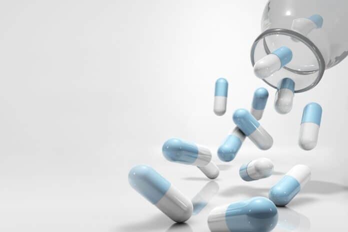 medicine capsules flying, falling out of glass container FARMACI