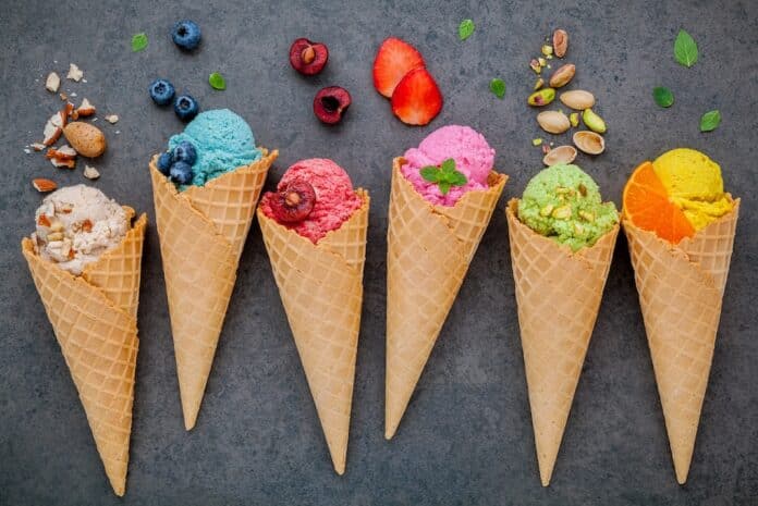 Various of ice cream flavor in cones blueberry ,strawberry ,pistachio ,almond ,orange and cherry setup on dark stone background . Summer and Sweet menu concept.