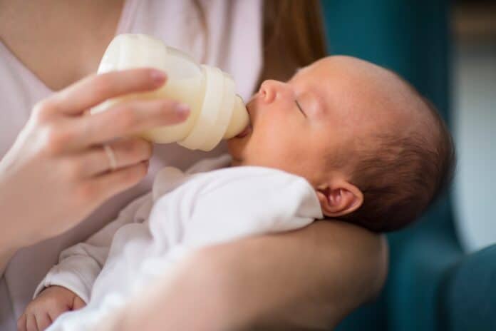 Close Up Of Loving Mother Feeding Newborn Baby Son With Bottle At Home LATTE ARTIFICIALE CRONOBACTER