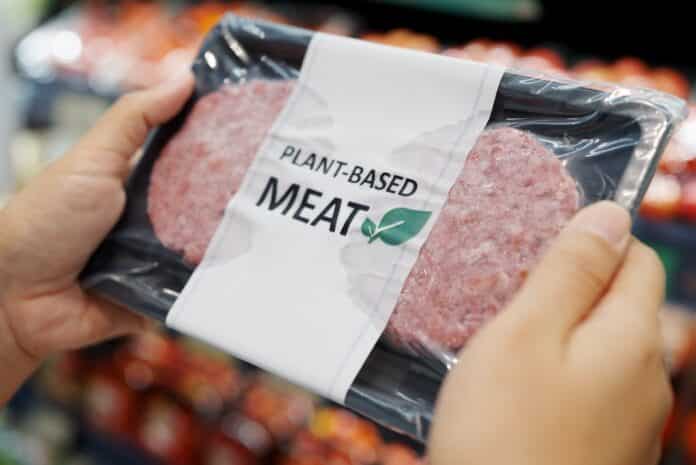Close-up hand carry choose zero pork soy bean faux peas cutlet gluten free read beyond non-meat lab label. Buy raw fake beef tray in asia store veggie burger patty for health care eat diet meal cook. PRODOTTI VEGAN SOSTITUTI DELLA CARNE