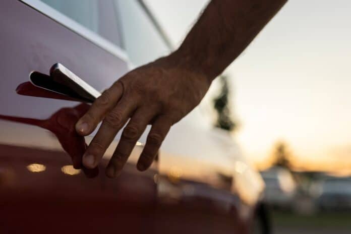 Hand reaching for tesla model s door handle at sunset maniglie, auto