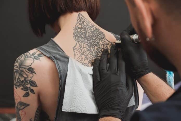 Professional artist making tattoo in salon TATUAGGI TUMORI