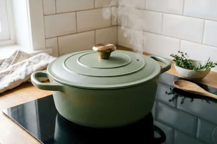 Olive green dutch oven on a stovetop in a bright kitchen setting casseruola, cocotte, casseruole
