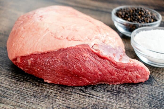 Ingredients for Grilled Picanha Steaks: Whole beef picanha with kosher salt and black pepper on a wood background carne