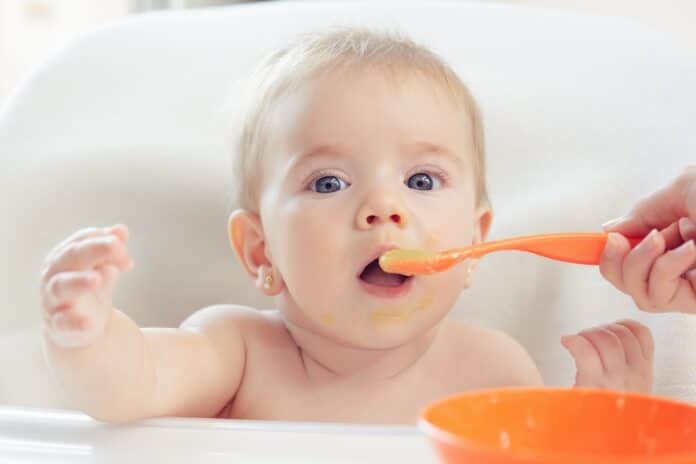 Bebé hermoso comiendo puré BABY FOOD METALLI PESANTI